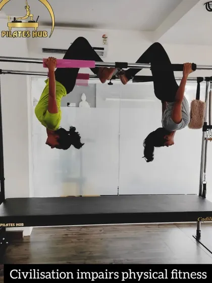 Two clients hang upside down from the Cadillac, a fun and challenging way to decompress the spine and build upper body strength.