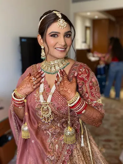 Simran looking absolutely radiant and happy. Her makeup enhances her natural features, giving her a timeless and elegant bridal look.