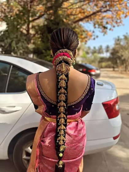 A stunning outdoor shot of a bride with a full temple jewellery 'Jadai', demonstrating how the hairstyle looks in natural light.