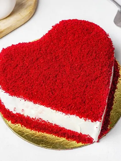 A top-down styled shot of a red velvet heart cake, perfect for special occasion promotions.