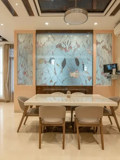 The dining area is defined by a beautiful stained-glass partition, adding color and artistry to the space.