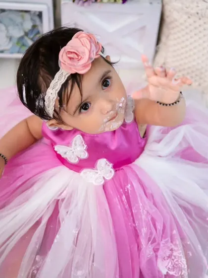 A sweet, upward glance from the birthday girl. Even covered in cake, her charm shines through in this adorable portrait.