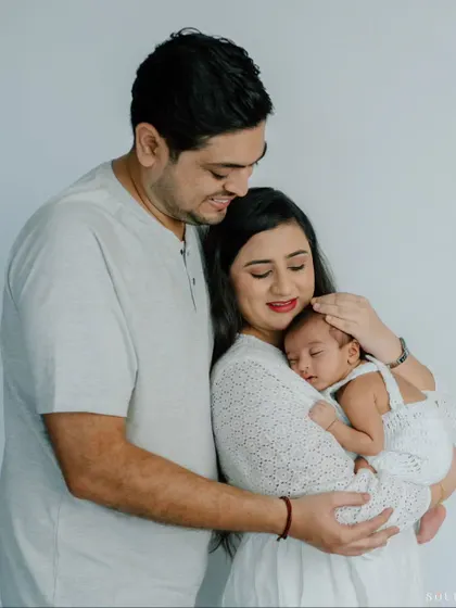 The snuggle is real. This portrait captures the warmth and security a newborn feels in their parents' arms, a perfect picture of a new family.