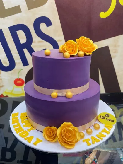 A bold purple 2kg two-tiered cake with contrasting yellow fondant roses.