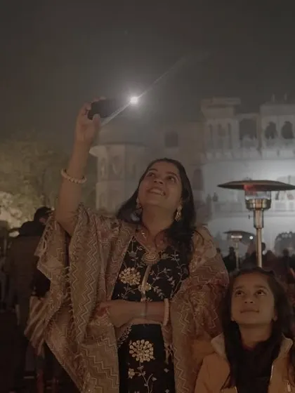 A mother and daughter watch a wedding drone show, their faces filled with wonder. We create moments that are not just for the couple, but for every generation present.