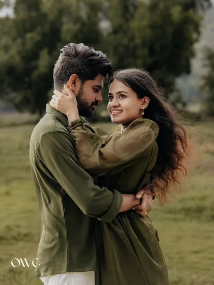 A loving embrace in a field, this photo captures the couple's smiles and the beautiful natural light.