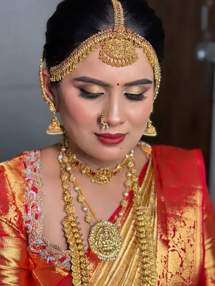 A close-up of this gorgeous bride's muhurtham makeup. The focus is on the dramatic golden eye makeup and the perfectly sculpted matha patti.