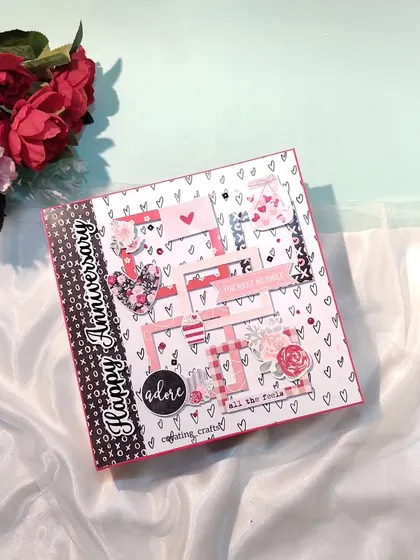 The cover of an anniversary scrapbook with layered frames and floral details.