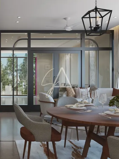 A view from the dining table towards the living area, framed by elegant glass doors. This open-concept design maintains a visual connection between spaces while allowing for separation when needed.
