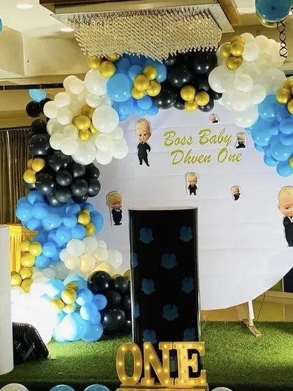 The Boss Baby theme is perfect for a little one who rules the house. This setup for Dhven's first birthday features character cutouts, a themed backdrop, and a professional blue, black, and gold color scheme.
