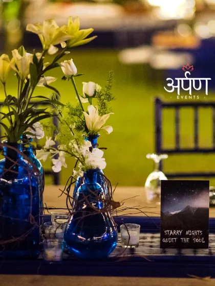 Attention to detail is key. For this "Starry Nights" themed party, even the table centerpieces, featuring blue vases and custom cards, were designed to enhance the magical ambiance of the evening.