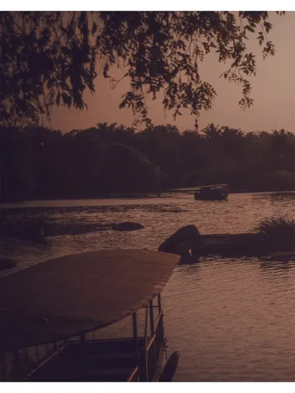 A boat on the river during sunset. The sepia tone gives this image a nostalgic and peaceful feeling.