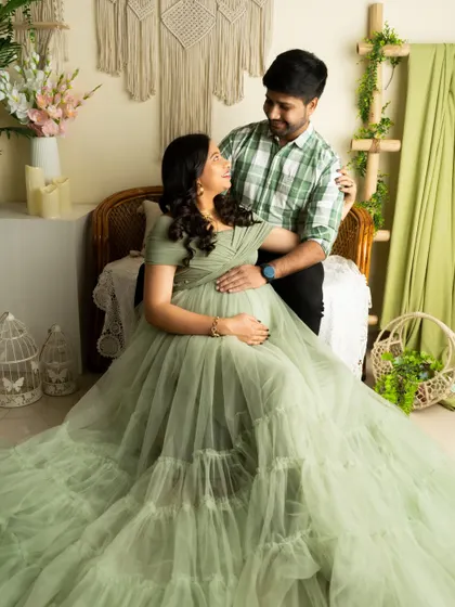 A loving gaze between partners. The coordinated outfits and the soft, natural setting create a peaceful and intimate portrait.