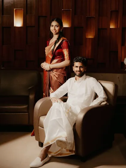 An elegant, full-length portrait of the South Indian couple in a modern, well-lit interior.
