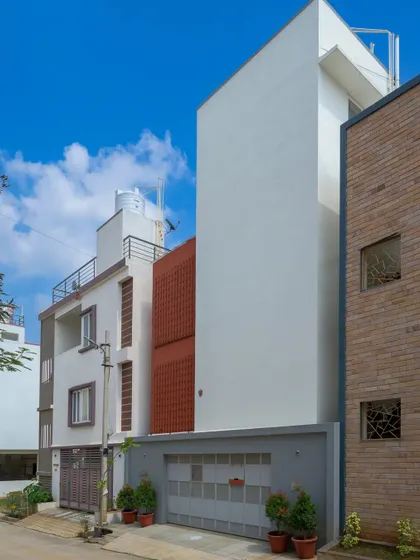 The minimalist exterior design of the home creates a strong contrast against the neighboring architectural fabric, making it a unique landmark on the street.