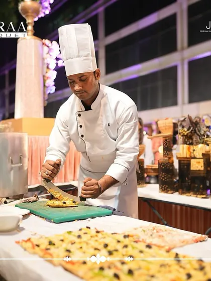 In the hands of our skilled chef, delicious cuisine becomes an art form. Here, a chef is preparing fresh vegetarian pizza at a live counter at Kiaraa Banquet.