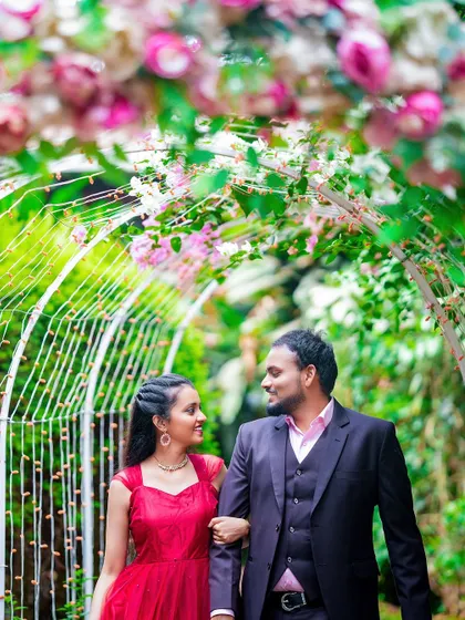 A close-up of a couple walking under a floral arch, focusing on their loving expressions.