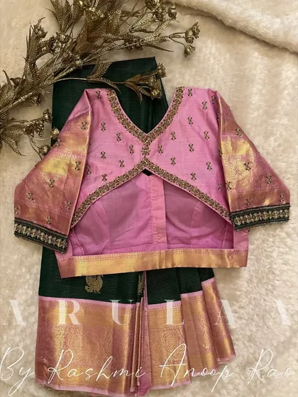 The back view of the pink and green combination, showing a V-shaped cutout framed with a delicate embroidered border.