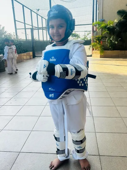 A young student fully geared up and ready for sparring practice.