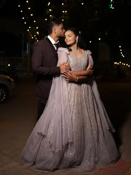 An embrace under the evening lights. This lavender tiered ball gown with cape sleeves creates a truly magical and romantic look for an engagement shoot.
