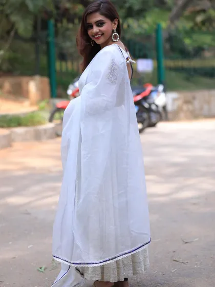 A side view of the white Anarkali, showing the sheer dupatta and the delicate lace trim on the hem.