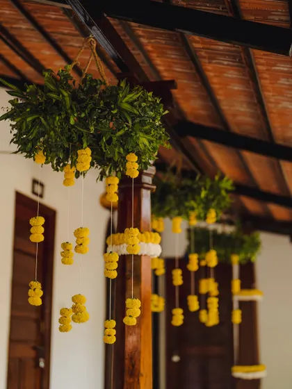 Hanging floral decorations made of marigolds and fresh green leaves add a traditional and festive touch to the venue's architecture.