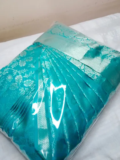A lovely turquoise saree, pleated and packed. The box folding makes it incredibly easy to take your favorite sarees with you on your travels.
