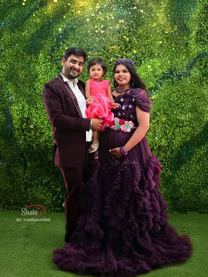 A beautiful family portrait during a maternity shoot. The mother is wearing a purple ruffle gown, and we also have options for matching outfits for the whole family.