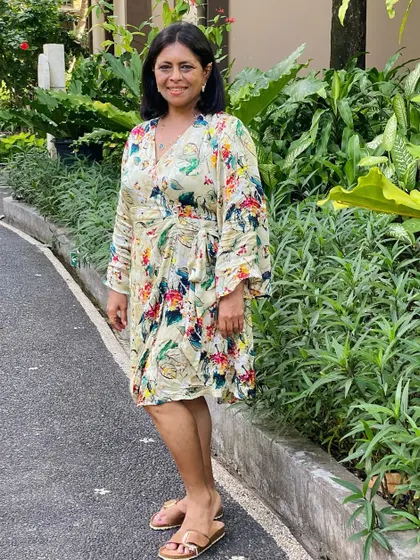 Posing in my tropical print dress against the lush greenery of Bali. My travels always inspire my designs.