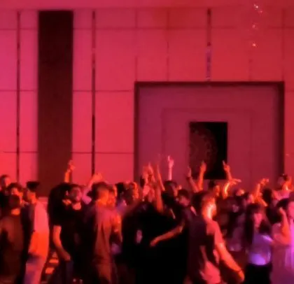 The room is bathed in red light as the employees dance.