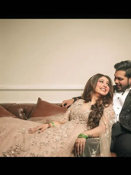 A relaxed and romantic portrait of the engaged couple on a leather sofa, sharing a look of love.