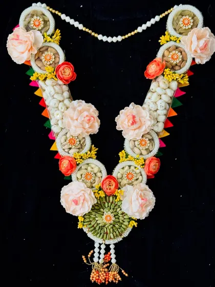 This stunning dry fruit and floral garland is a luxurious Holi gift. It combines sections of premium nuts with beautiful artificial flowers, creating an elegant and healthy festive present.