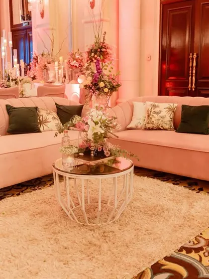 Comfort and elegance were key for this ring ceremony lounge. I chose plush, curved sofas in a soft blush pink, accented with floral and dark green cushions for a sophisticated and inviting space.