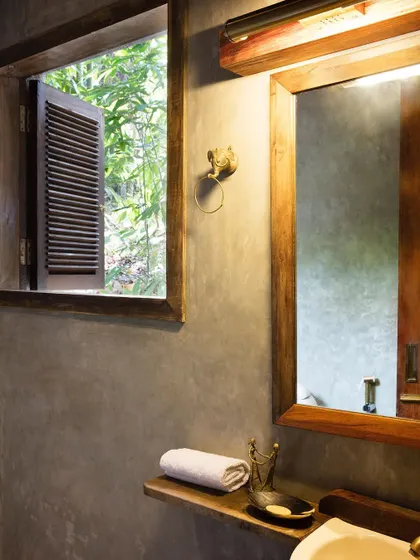 The bathroom of the Garden Room at Jalakara, with its simple, elegant combination of polished cement and wood.