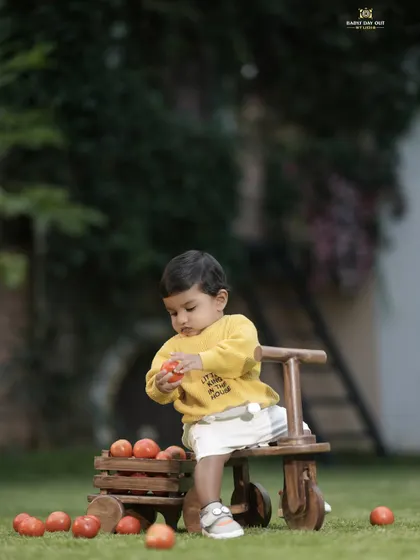 A little boy playing with tomatoes in the garden. We use simple, natural props to create authentic and playful moments.