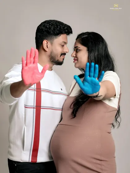 Another creative take on a gender reveal photo. This image uses colored paint on the couple's hands to create a memorable and artistic announcement.