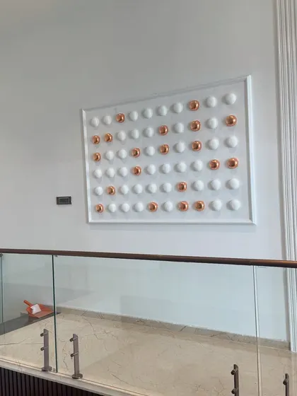 A wider view of the symmetrical relief art, showing how it complements the modern interior with its glass railings and textured wall panels. It's a subtle piece that makes a big impact.