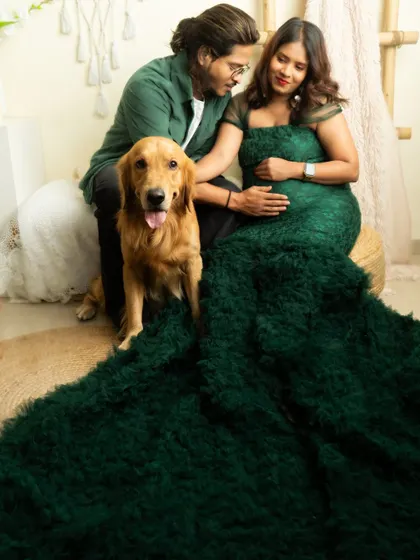 A family portrait including the beloved family dog. The rich green gown and natural studio setup create a beautiful, cohesive look.