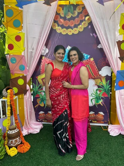 Posing with a friend at the 'Wonders of Women' event. My red and black leheriya and bandini saree stood out with its bold, traditional patterns.