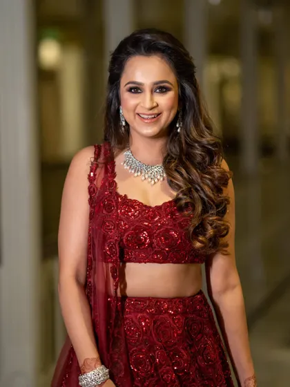 A close-up portrait of a bride, her happy smile and diamond necklace shining brightly.