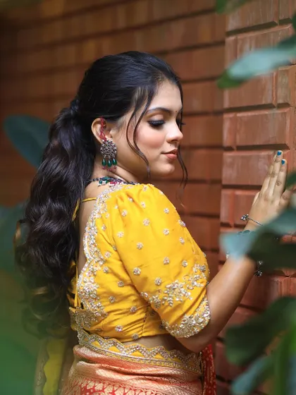 A side profile of the model, showing how the wavy ponytail beautifully complements her features.