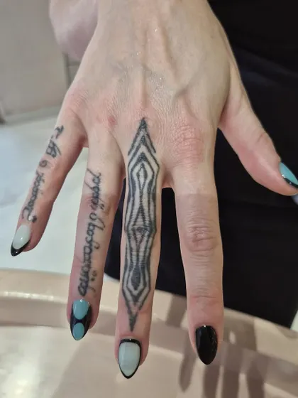 This client's hand tattoos pair perfectly with our custom geometric nail art. We love creating designs that complement your personal style.