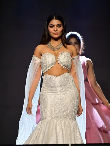 Walking the runway with confidence. The makeup is designed to be seen from afar, with highlighted cheekbones and bold eyes that command attention.