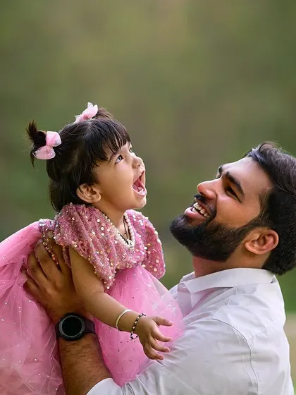 A father lifting his daughter up in the air, a classic portrait of pure happiness. Her joyful expression and the loving look on his face make this a truly priceless memory from their family photoshoot.