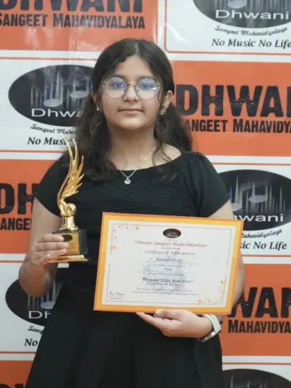 A young keyboardist proudly displays her certificate and trophy.