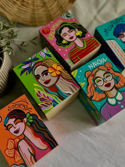 A set of personalized pen stands, each with a hand-painted portrait and the person's name.