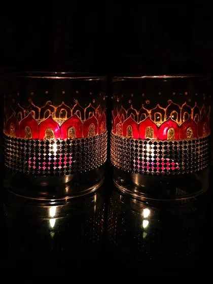This pair of lamp chimneys features a red and gold pattern. The warm colors create a wonderfully rich and festive glow, ideal for Diwali celebrations.
