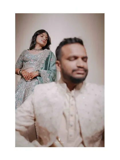 An artistic shot with the groom in the foreground, slightly out of focus, and the bride looking on from behind. This creates a sense of depth and story.