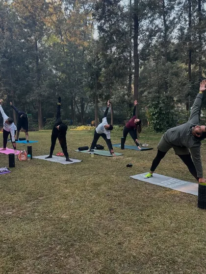 The whole group joins in for post-run yoga, holding Triangle Pose (Trikonasana) to stretch the sides of the body and improve balance.