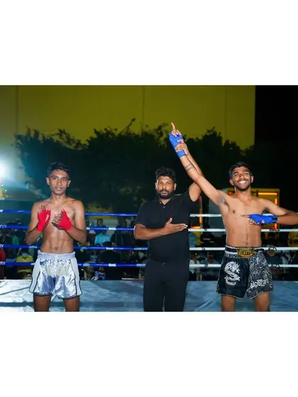 The referee raises the hand of our victorious fighter. This moment captures the culmination of a successful fight camp.